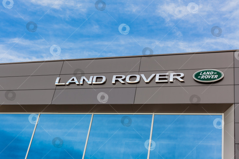 Скачать Логотип бренда Land Rover на фоне ярко-голубого неба фотосток Ozero