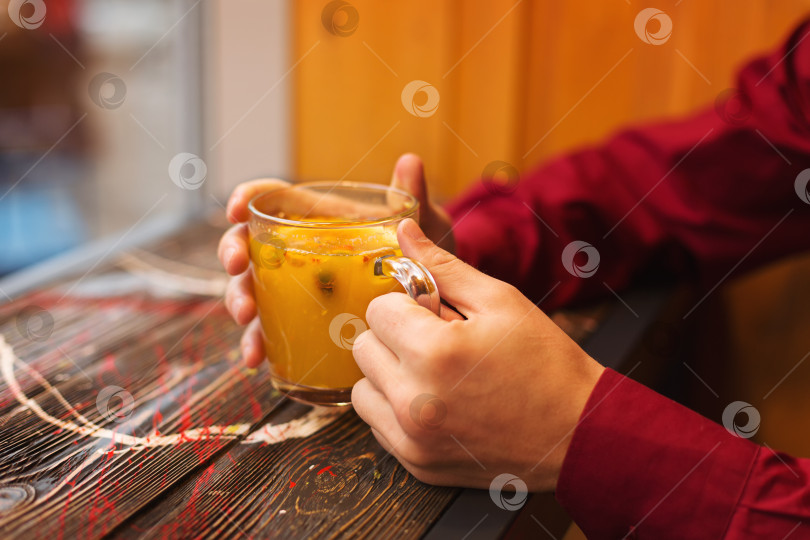 Скачать Парень пьет чай в кафе осенью фотосток Ozero