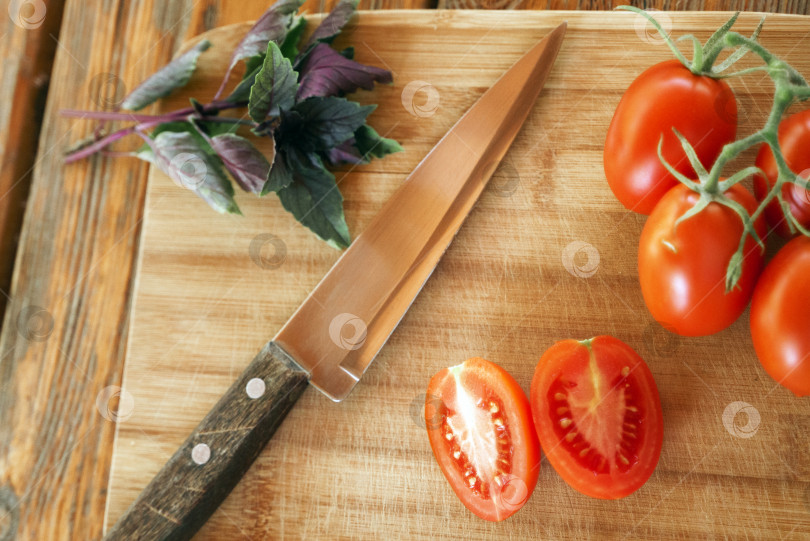 Скачать Базилик, помидоры на веточке, порезанный помидор и нож фотосток Ozero