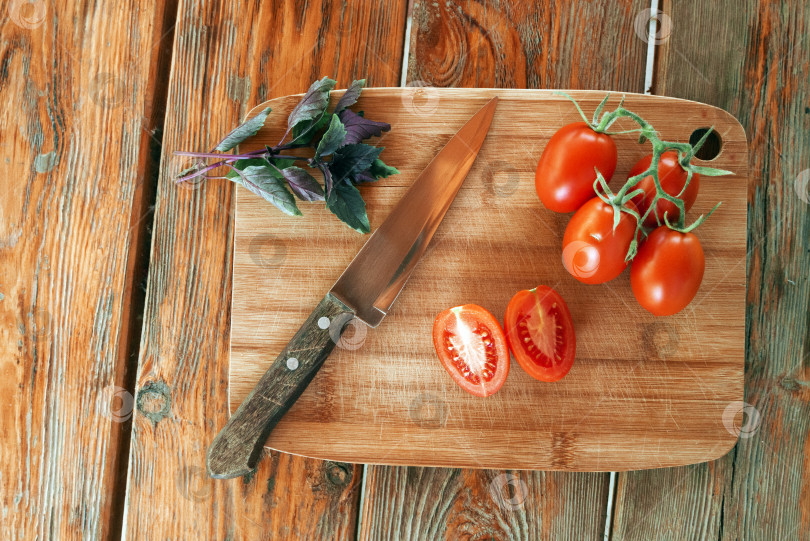 Скачать Базилик, помидоры на веточке, порезанный помидор и нож фотосток Ozero