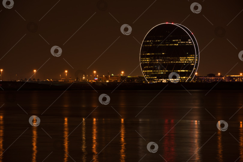 Скачать Вид на здание штаб-квартиры Aldar и ночной пейзаж Абу-Даби фотосток Ozero
