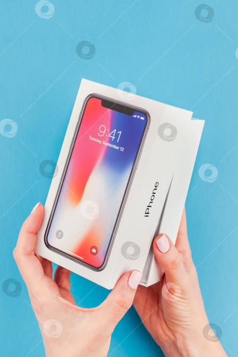 Скачать Женщина протягивает коробку с Apple iPhone X фотосток Ozero