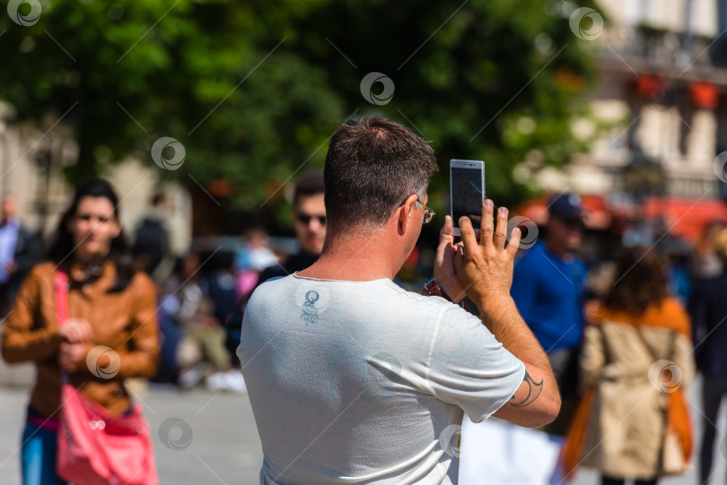 Скачать Мужчина фотографирует на улице фотосток Ozero