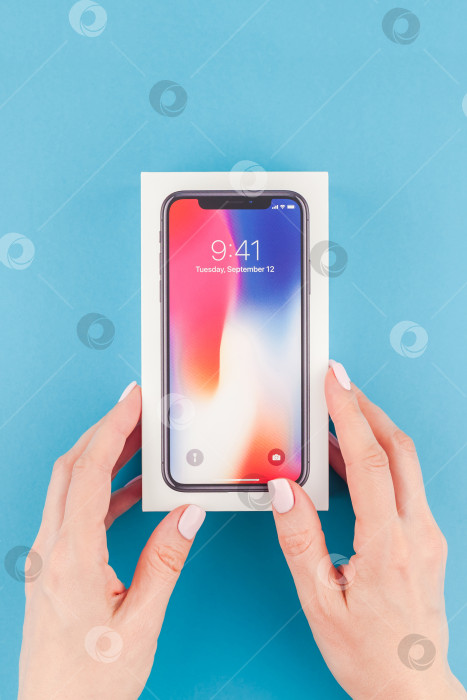 Скачать Женщина протягивает коробку с Apple iPhone X фотосток Ozero