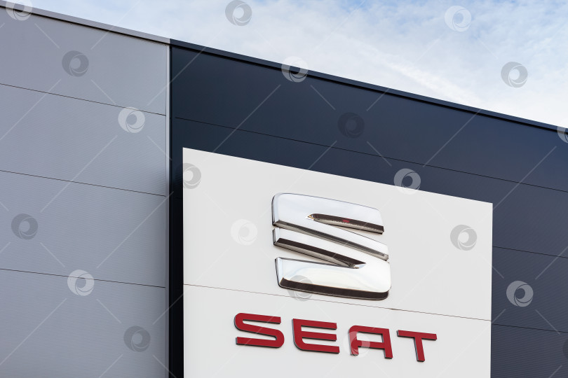 Скачать Логотип бренда SEAT на фоне ярко-голубого неба фотосток Ozero