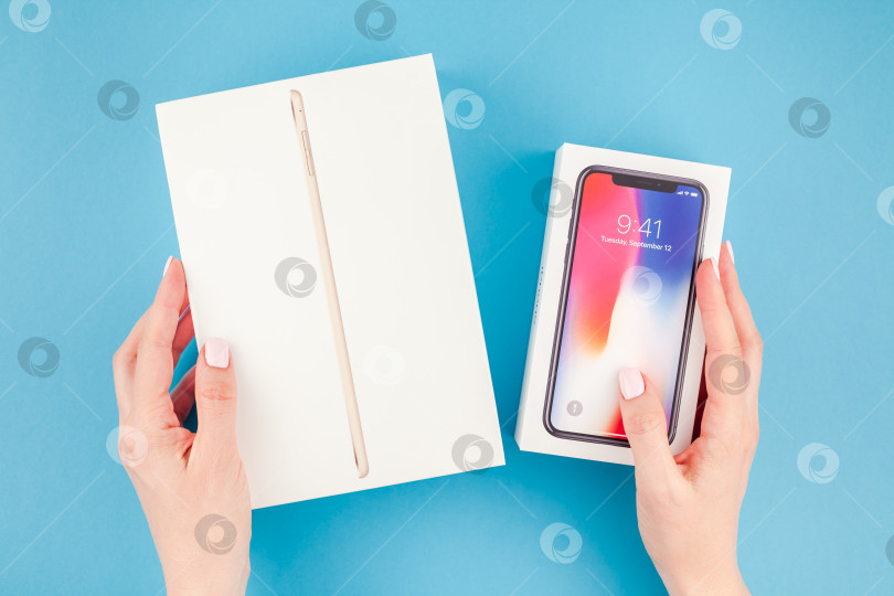 Скачать Женщина держит в руках коробку с устройствами Apple фотосток Ozero