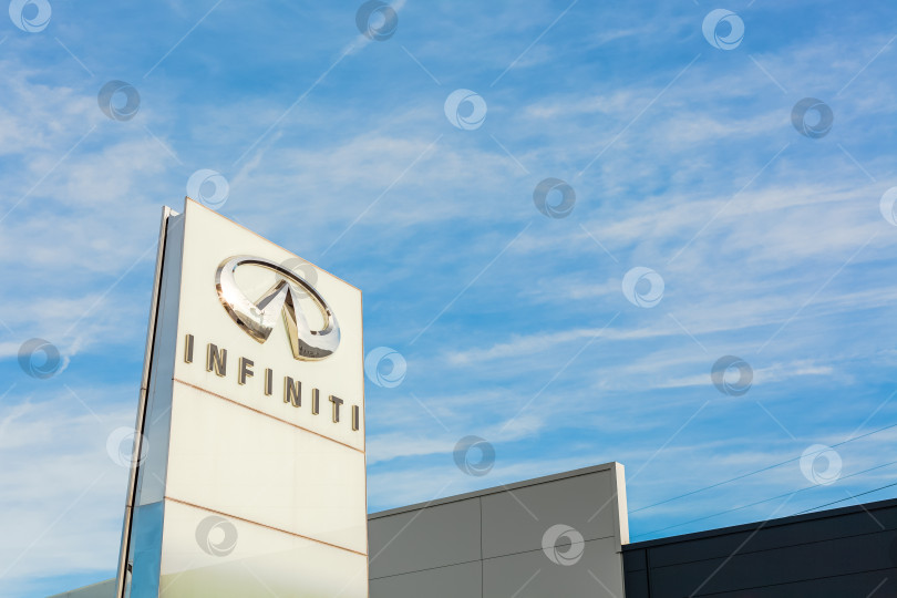 Скачать Логотип бренда Infiniti на фоне ярко-голубого неба фотосток Ozero