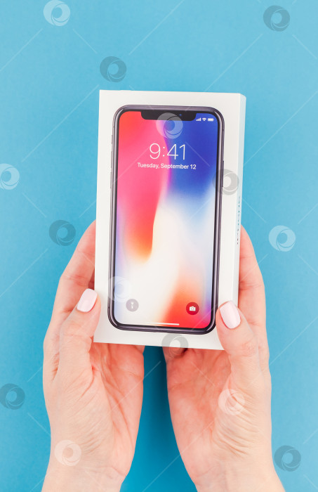 Скачать Женщина протягивает коробку с Apple iPhone X фотосток Ozero
