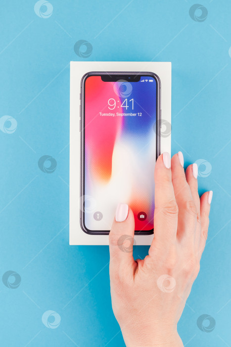 Скачать Женщина протягивает коробку с Apple iPhone X фотосток Ozero