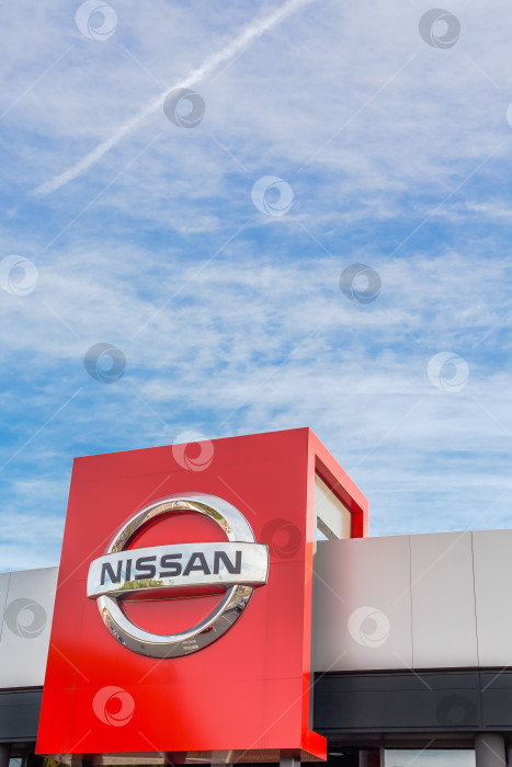Скачать Логотип бренда Nissan на фоне ярко-голубого неба фотосток Ozero