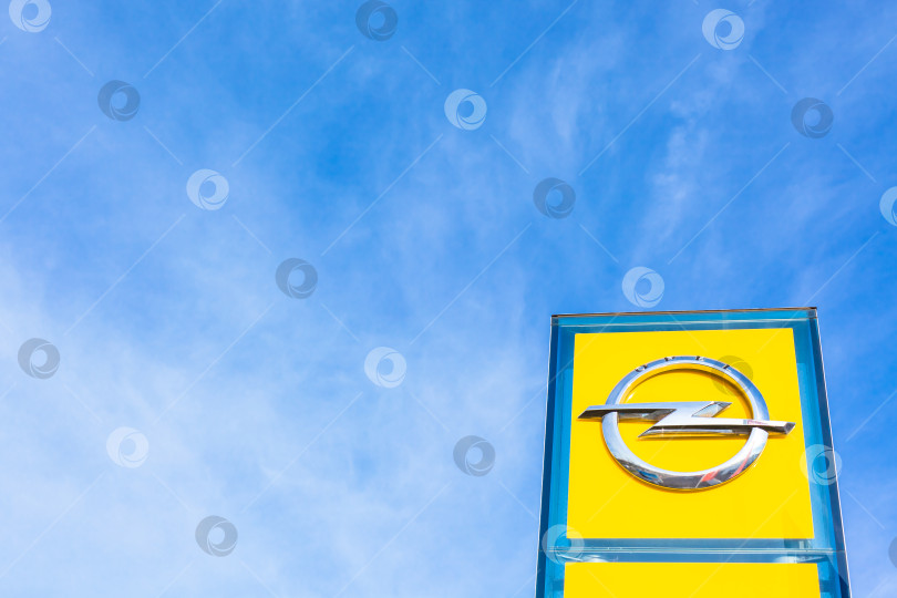 Скачать Логотип бренда Opel на фоне ярко-голубого неба фотосток Ozero