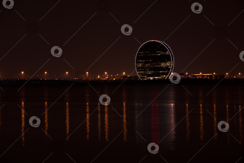 Скачать Вид на здание штаб-квартиры Aldar и ночной пейзаж Абу-Даби фотосток Ozero