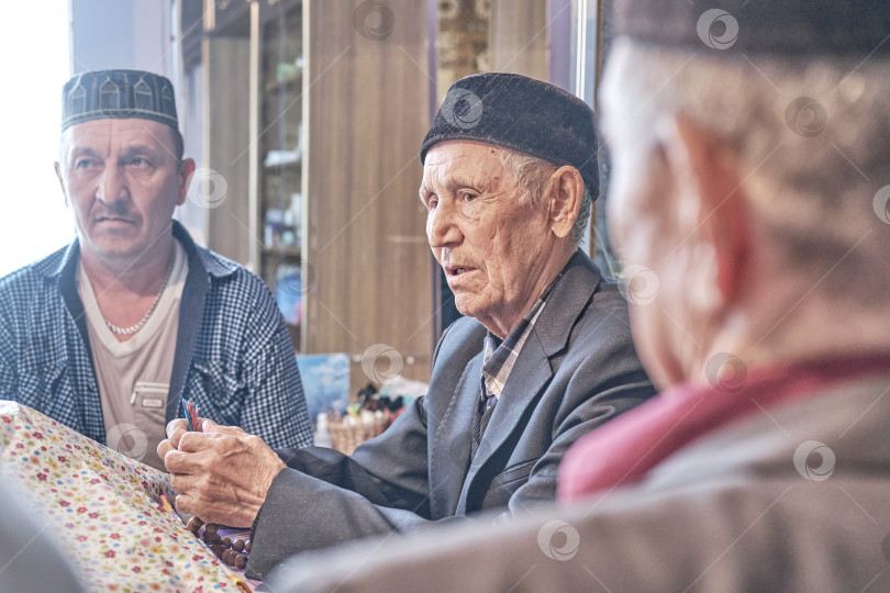 Скачать Мулла произносит проповедь дома в сибирской деревне. фотосток Ozero