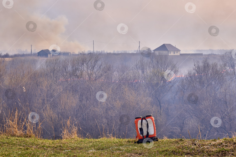 Скачать Противопожарный рюкзак на фоне массового лесного пожара. фотосток Ozero