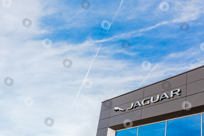 Скачать Логотип бренда Jaguar на фоне ярко-голубого неба фотосток Ozero