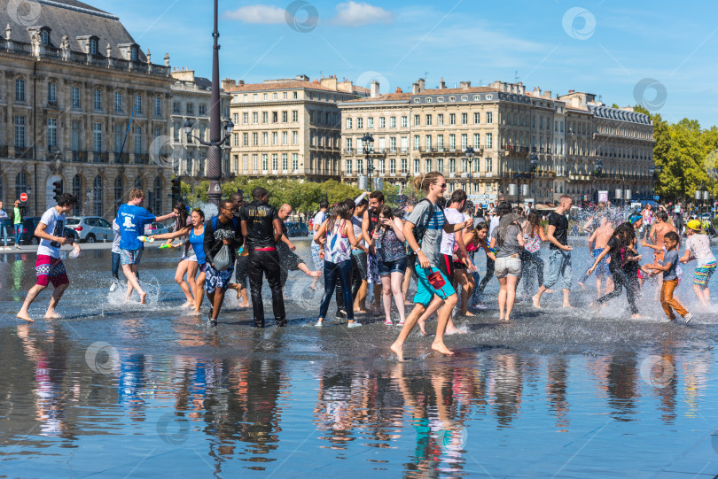 Скачать Люди развлекаются в зеркальном фонтане в Бордо, Франция фотосток Ozero
