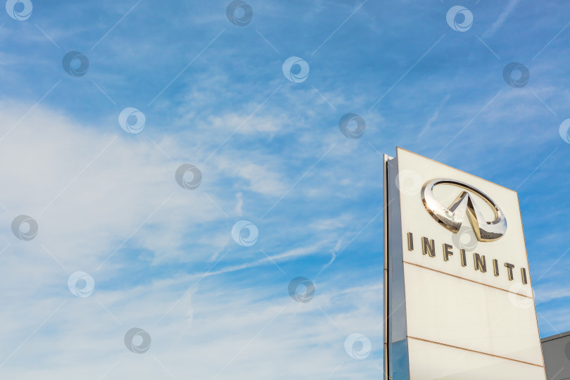 Скачать Логотип бренда Infiniti на фоне ярко-голубого неба фотосток Ozero