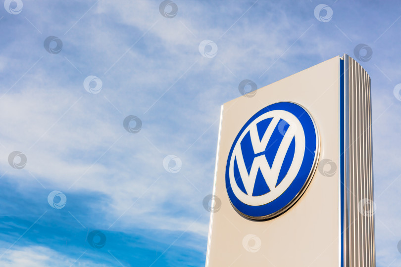 Скачать Логотип бренда Volkswagen на фоне голубого неба фотосток Ozero