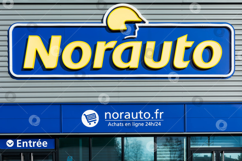 Скачать Логотип бренда Norauto на фоне ярко-голубого неба фотосток Ozero