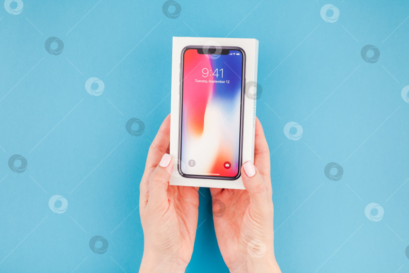 Скачать Женщина протягивает коробку с Apple iPhone X фотосток Ozero