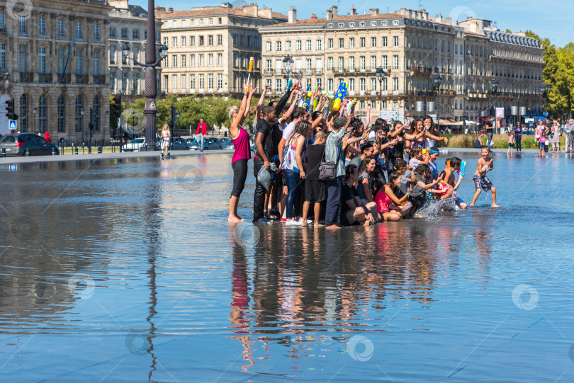 Скачать Люди развлекаются в зеркальном фонтане в Бордо, Франция фотосток Ozero
