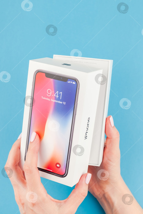 Скачать Женщина протягивает коробку с Apple iPhone X фотосток Ozero
