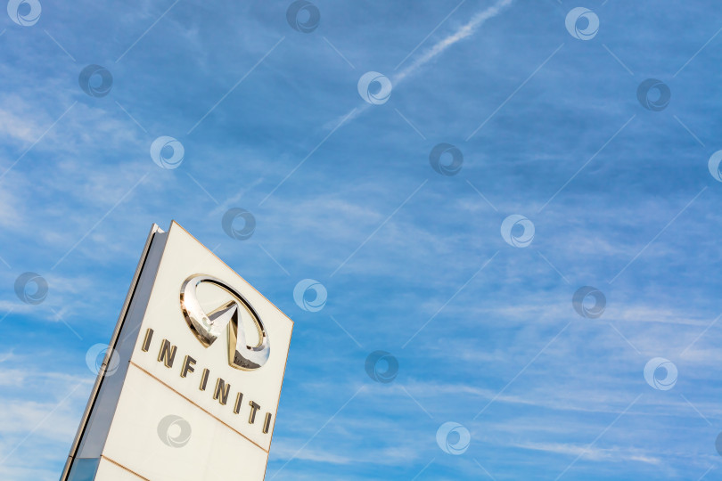 Скачать Логотип бренда Infiniti на фоне ярко-голубого неба фотосток Ozero