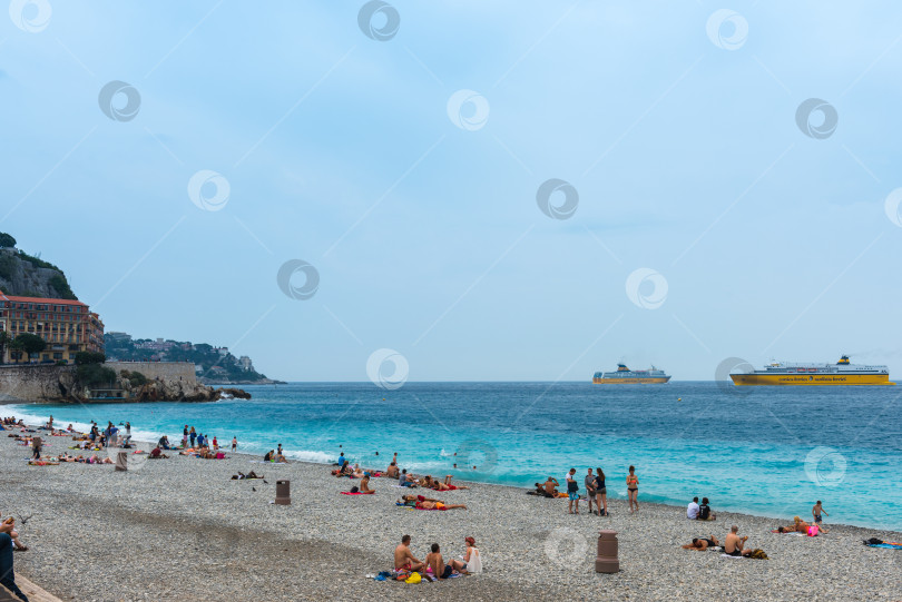 Скачать Люди на пляже Средиземного моря в Ницце фотосток Ozero