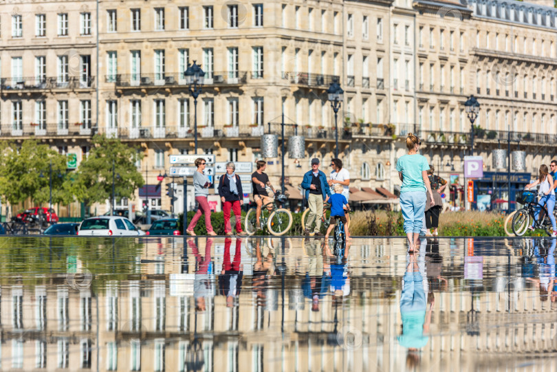 Скачать Люди катаются на велосипедах у фонтана в Бордо, Франция фотосток Ozero