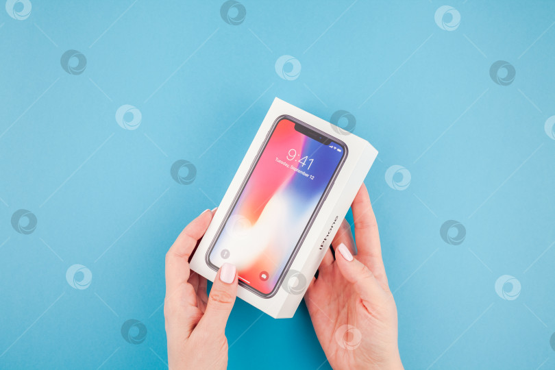 Скачать Женщина протягивает коробку с Apple iPhone X фотосток Ozero