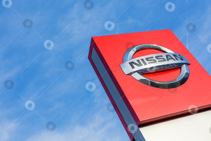 Скачать Логотип бренда Nissan на фоне ярко-голубого неба фотосток Ozero