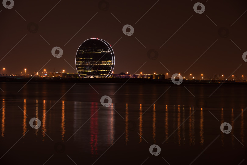 Скачать Вид на здание штаб-квартиры Aldar и ночной пейзаж Абу-Даби фотосток Ozero
