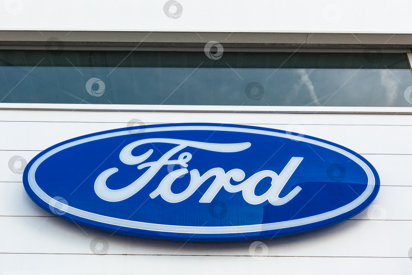 Скачать Логотип бренда Ford на фоне ярко-голубого неба фотосток Ozero