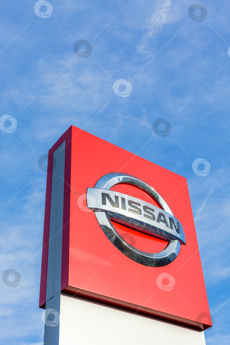 Скачать Логотип бренда Nissan на фоне ярко-голубого неба фотосток Ozero