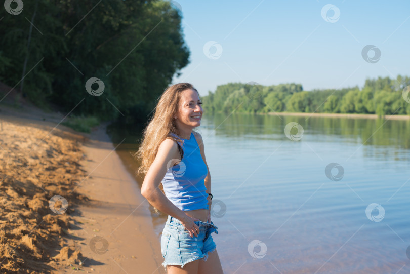 Скачать Женщина стоит на пляже у водоема фотосток Ozero