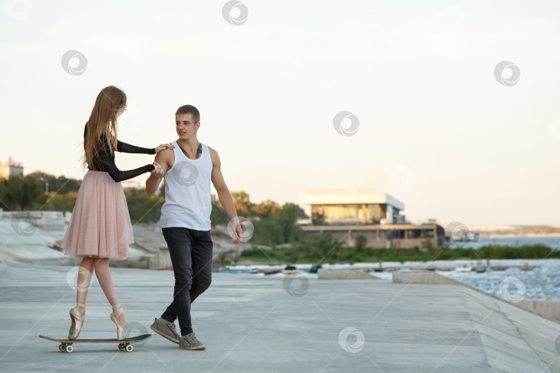 Скачать Балерина на скейтборде. Парень помогает фотосток Ozero