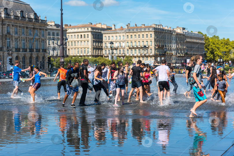 Скачать Люди развлекаются в зеркальном фонтане в Бордо, Франция фотосток Ozero