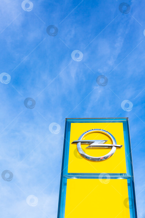 Скачать Логотип бренда Opel на фоне ярко-голубого неба фотосток Ozero