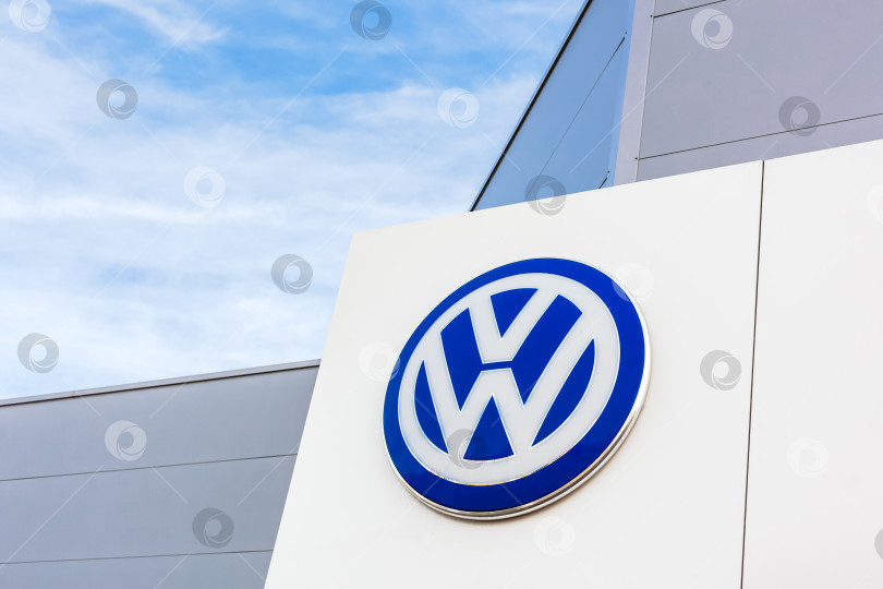 Скачать Логотип бренда Volkswagen на фоне голубого неба фотосток Ozero
