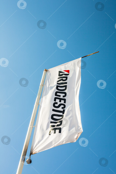 Скачать Флаг Bridgestone с логотипом на фоне голубого неба фотосток Ozero