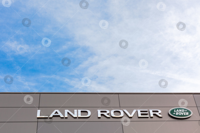 Скачать Логотип бренда Land Rover на фоне ярко-голубого неба фотосток Ozero