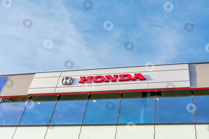 Скачать Логотип бренда Honda на фоне ярко-голубого неба фотосток Ozero