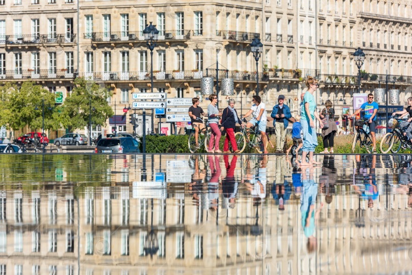 Скачать Люди катаются на велосипедах у фонтана в Бордо, Франция фотосток Ozero