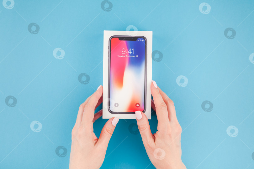 Скачать Женщина протягивает коробку с Apple iPhone X фотосток Ozero