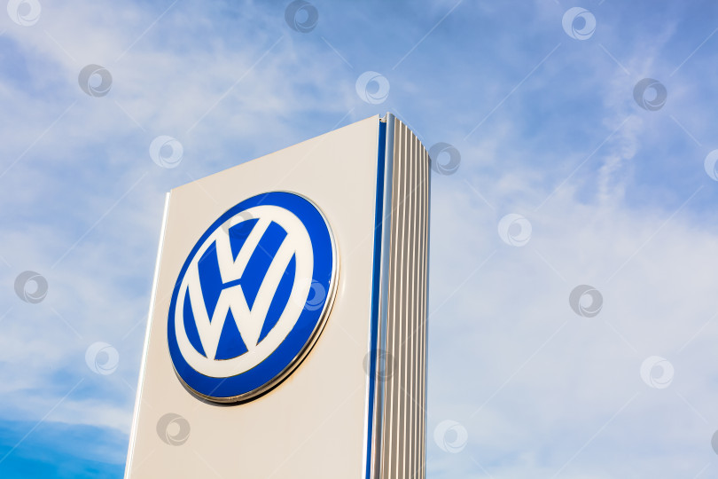 Скачать Логотип бренда Volkswagen на фоне голубого неба фотосток Ozero