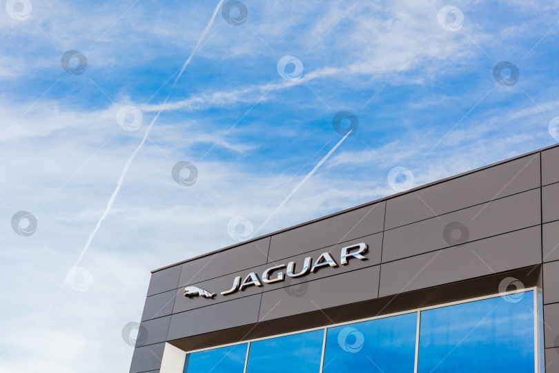 Скачать Логотип бренда Jaguar на фоне ярко-голубого неба фотосток Ozero