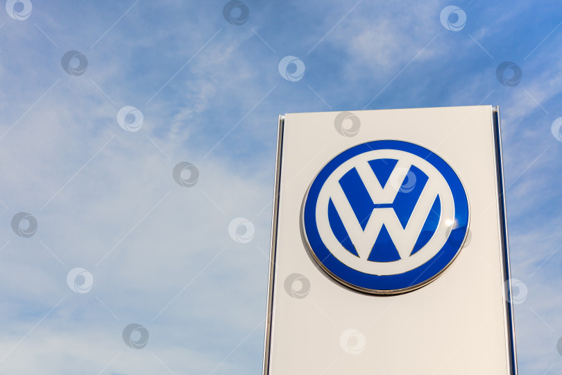 Скачать Логотип бренда Volkswagen на фоне голубого неба фотосток Ozero