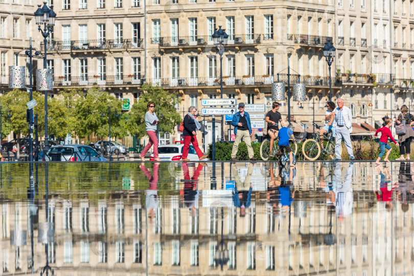 Скачать Люди катаются на велосипедах у фонтана в Бордо, Франция фотосток Ozero