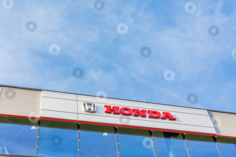 Скачать Логотип бренда Honda на фоне ярко-голубого неба фотосток Ozero