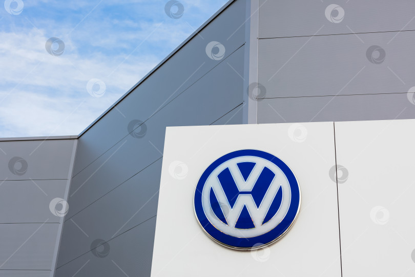 Скачать Логотип бренда Volkswagen на фоне голубого неба фотосток Ozero
